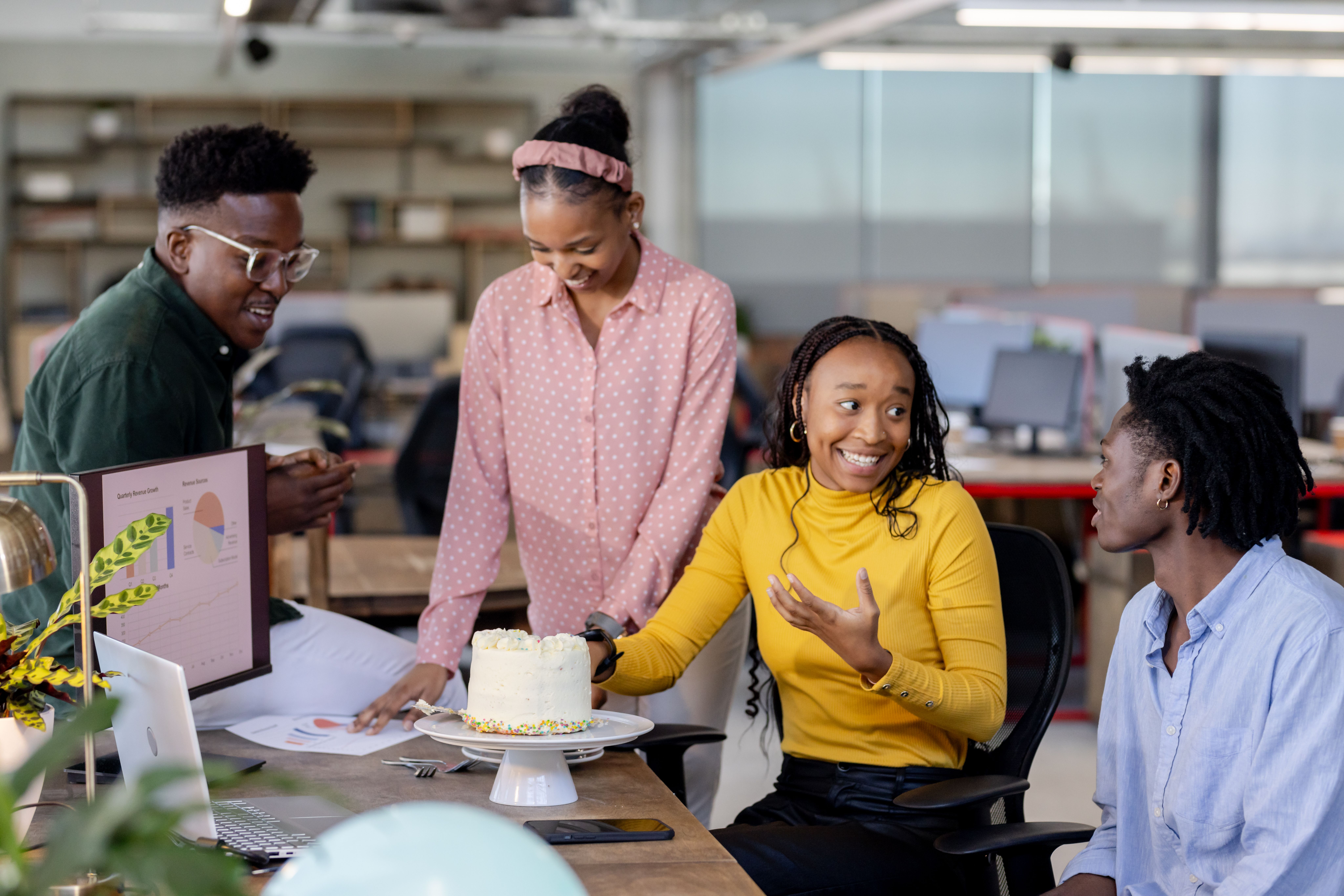 A sales team celebrating a deal with a cake